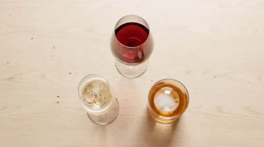 Trois verres Lehmann (vin rouge, champagne, cocktail) disposés sur une table en bois.